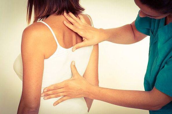 a doctor examines the back for thoracic osteochondrosis
