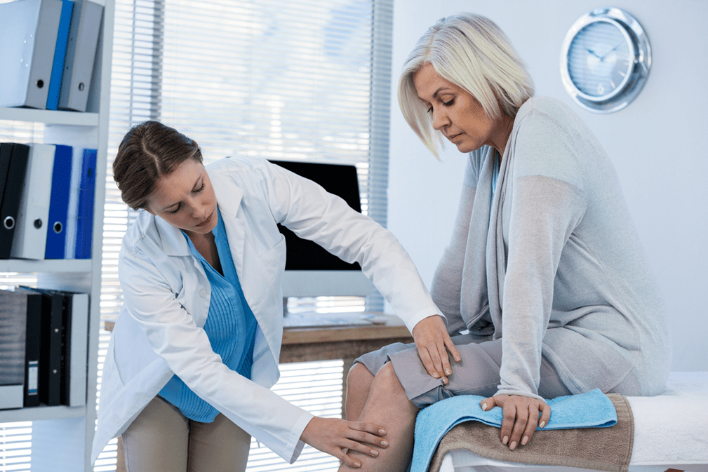 A patient with osteoarthritis requiring treatment being examined by a doctor